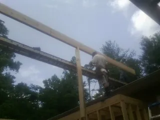 Carpenter setting a ridge beam over a new addition frame — Ice Dam Removal by Roofing Brothers in Rockbridge Baths