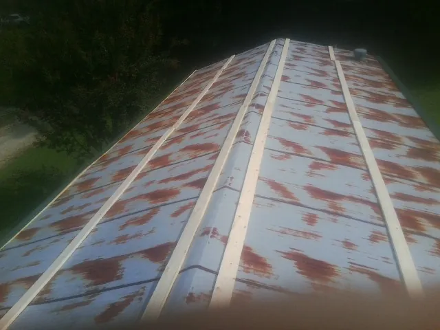 Rusted metal roof panels with new wood purlins before replacement — Storm Damage Roof Repair in Rockbridge Baths by Roofing Brothers