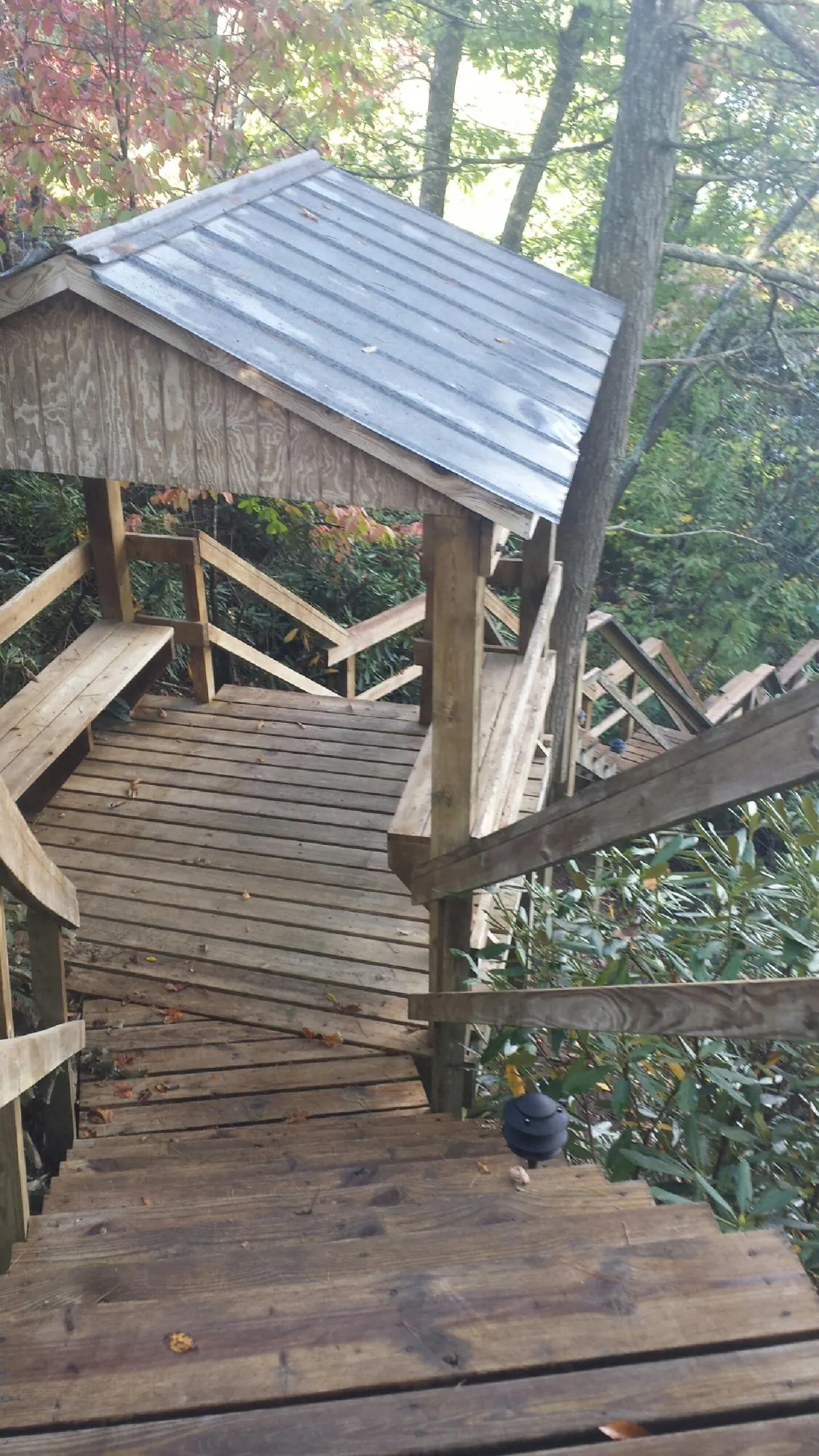 Metal roofed shelter over wooden steps on a wooded walkway — Skylight Repair & Installation work by our crew in Rockbridge Baths