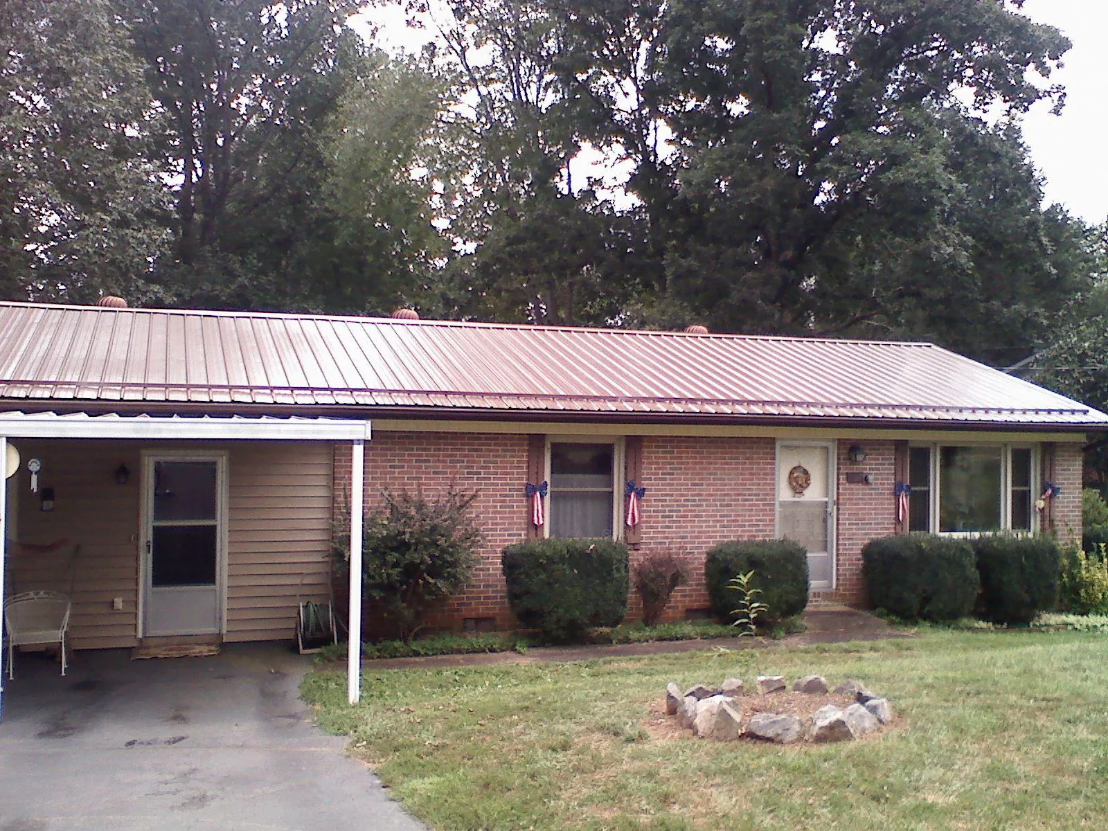 Bronze metal roof and carport on a brick ranch home — Roof Repair work by our crew in Rockbridge Baths